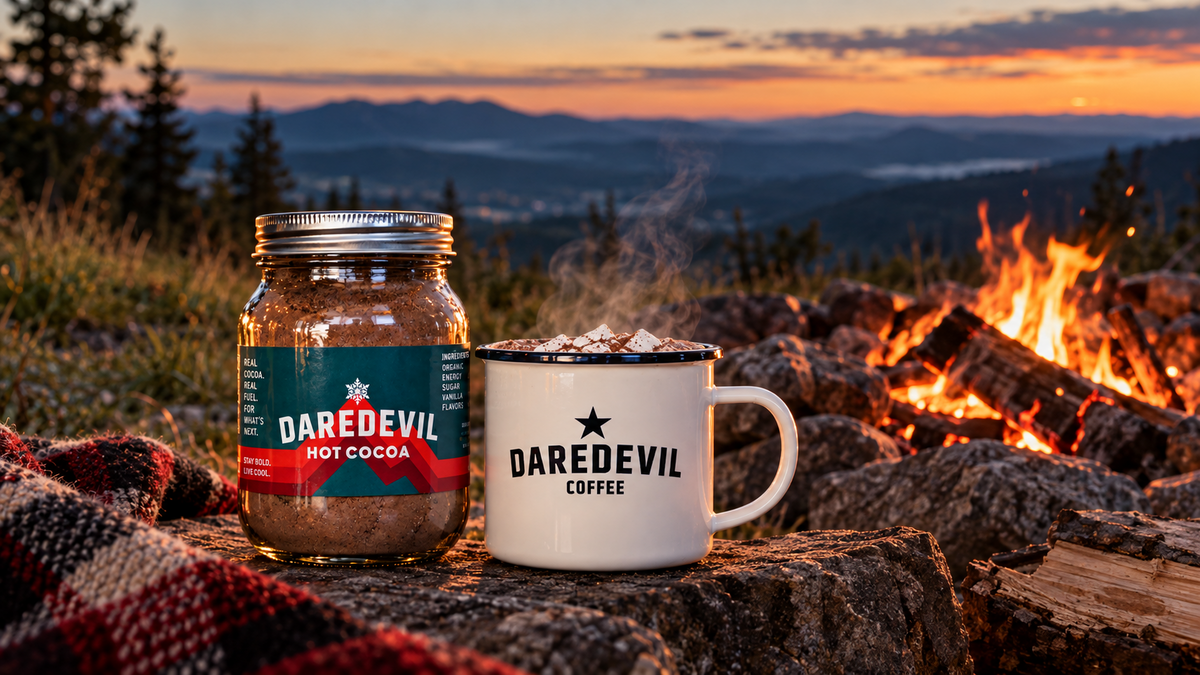 Daredevil hot cocoa and mug beside a mountain campfire at sunset